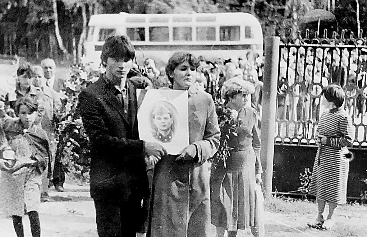 Татьяна Пуминова несет портрет Вячеслава на похоронах.